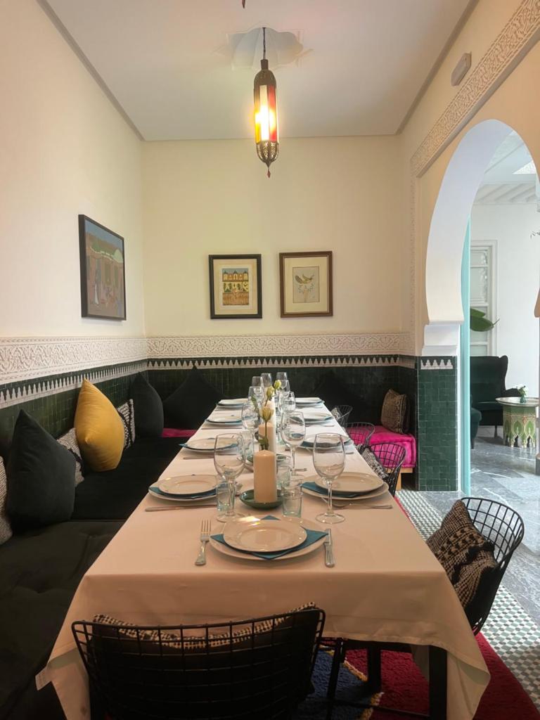 une salle à manger avec une longue table et des chaises dans l'établissement Riad Albatoul, à Marrakech