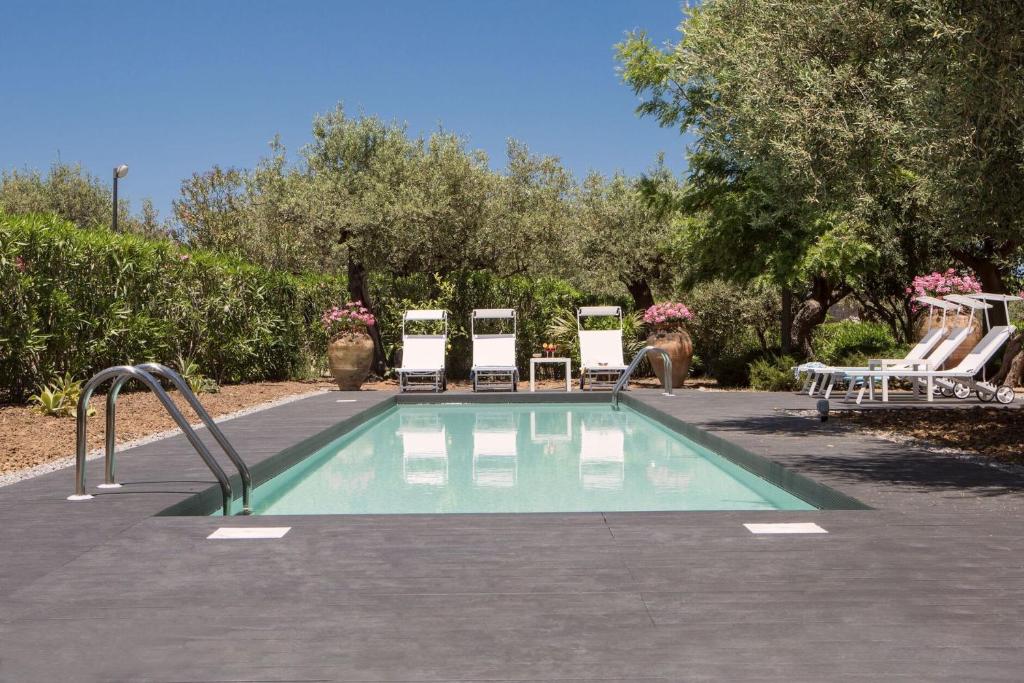 - une piscine avec 2 chaises et des adozenitures dans l'établissement Villa Mazzaforno a Cefalu' by Wonderful Italy, à Cefalù