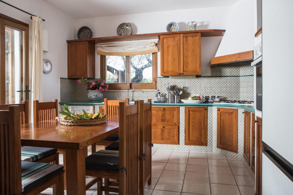 une cuisine avec des armoires en bois et une table en bois dans l'établissement Villa Mazzaforno a Cefalu' by Wonderful Italy, à Cefalù