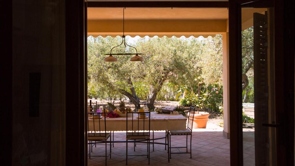 une salle à manger avec une table et des chaises sur un patio dans l'établissement Villa Mazzaforno a Cefalu' by Wonderful Italy, à Cefalù