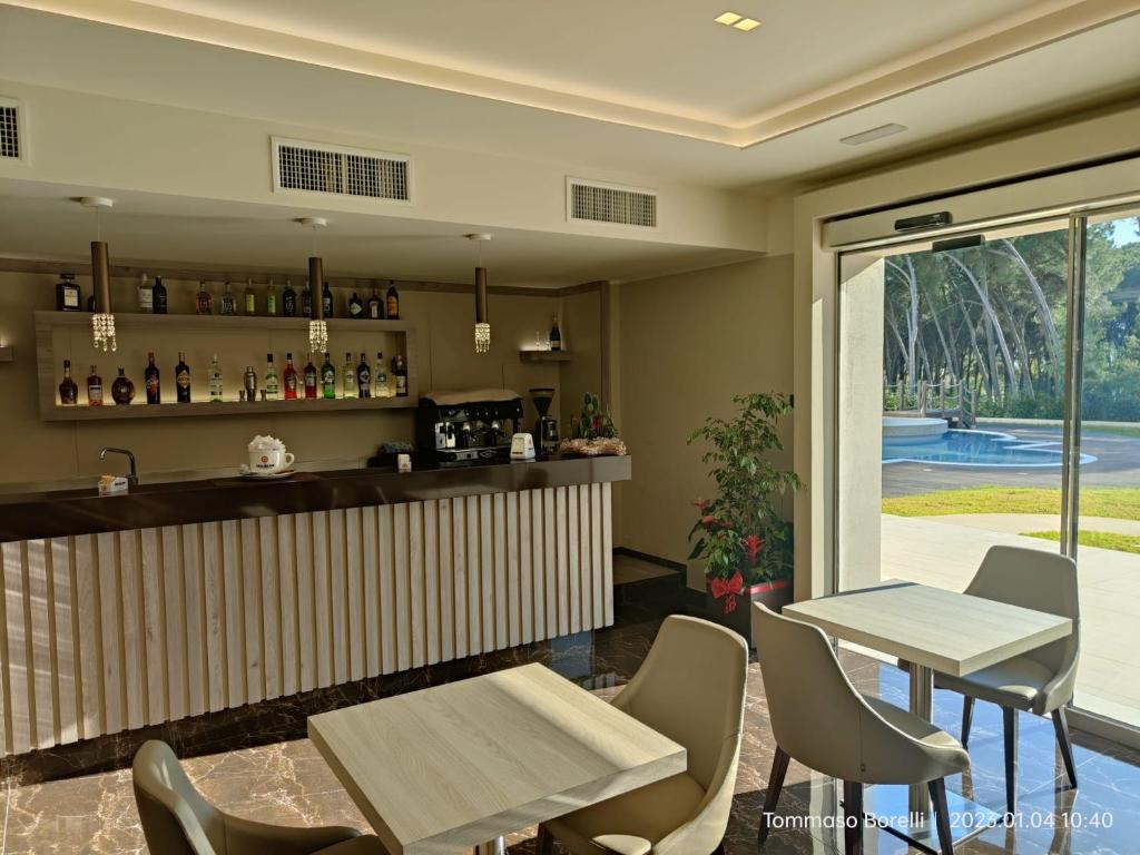 un restaurant avec un bar avec des chaises et des tables dans l'établissement PARK HOTEL LE DUNE DI GIOVINO, à Catanzaro Lido