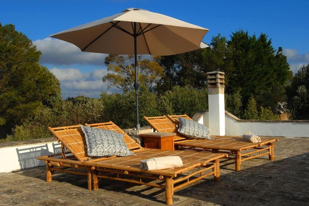 - un ensemble de chaises longues avec un parasol dans l'établissement Beautiful Trulli in the heart of the Valle d Itria, à Ostuni