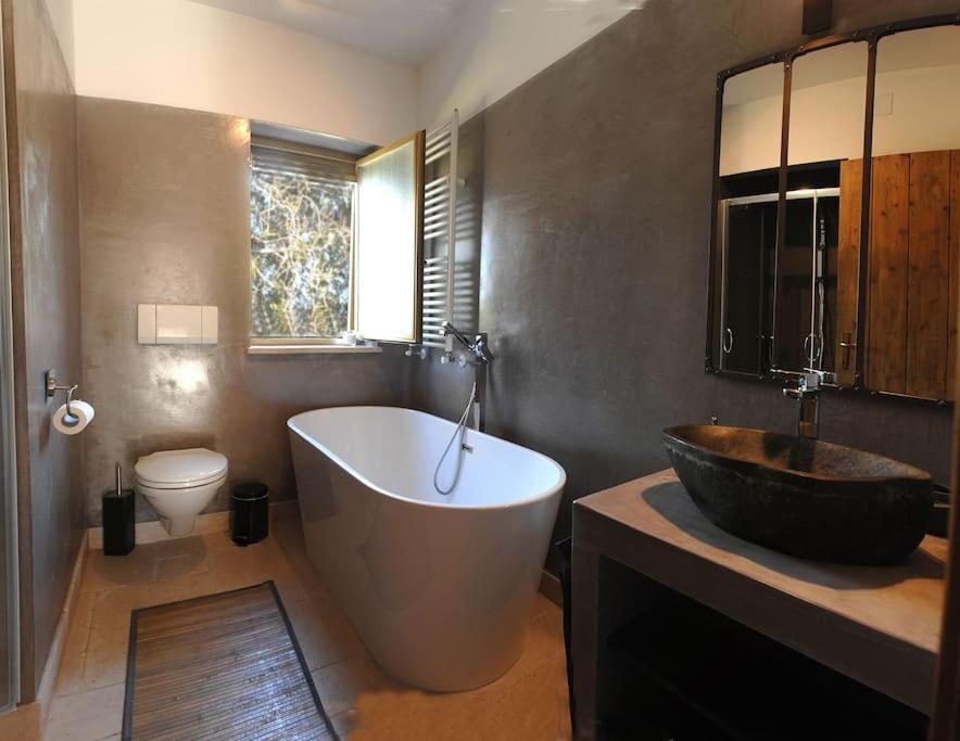 La salle de bains est pourvue d'une grande baignoire et de toilettes. dans l'établissement Beautiful Trulli in the heart of the Valle d Itria, à Ostuni 28 autres photos