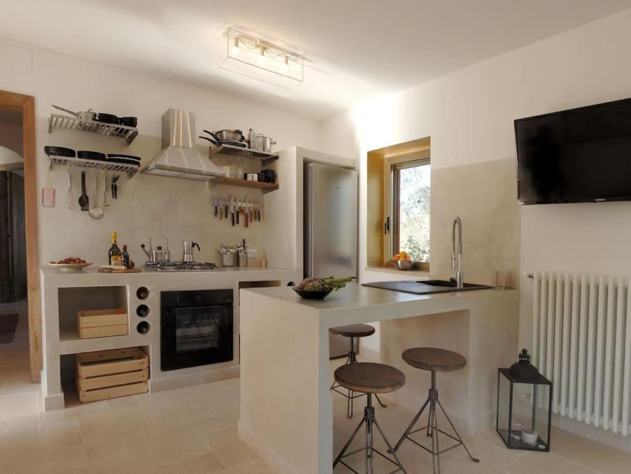 - une cuisine avec un comptoir et deux tabourets dans l'établissement Beautiful Trulli in the heart of the Valle d Itria, à Ostuni