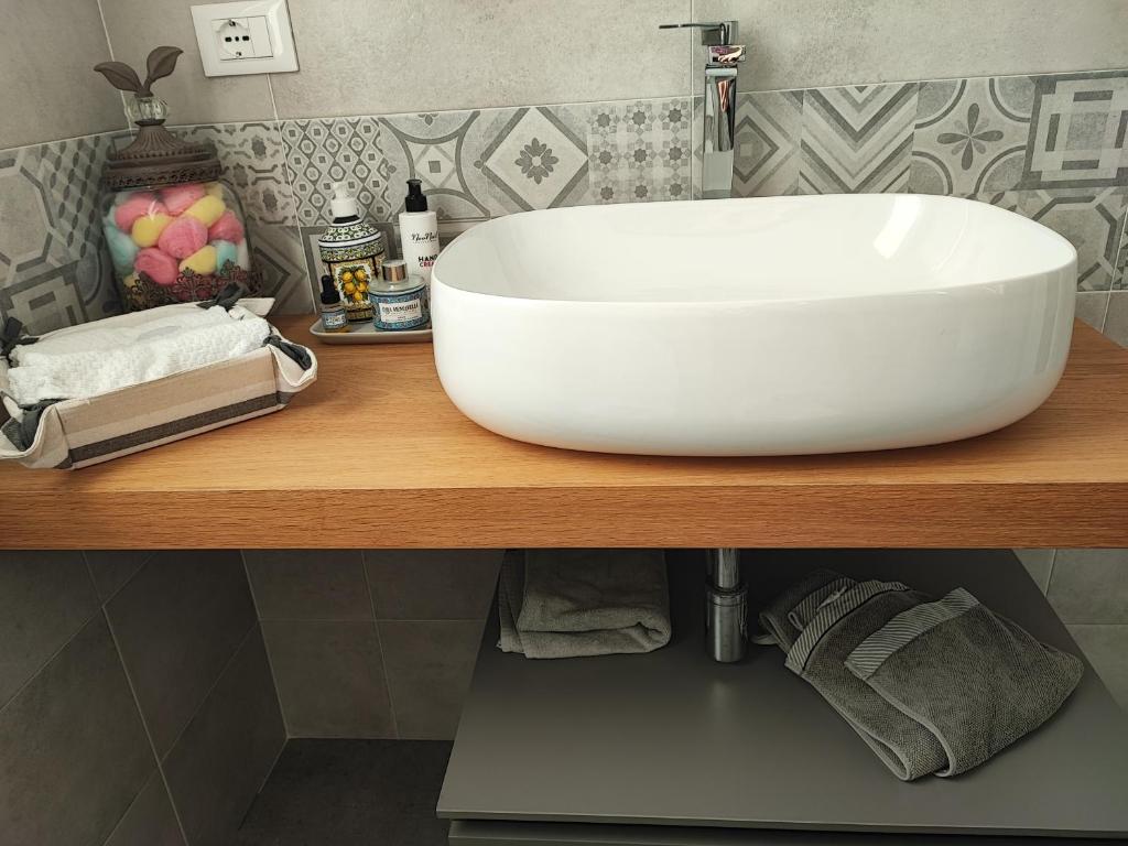 un lavabo blanc sur un comptoir en bois dans une salle de bain dans l'établissement Villa Theoma, à Castelnuovo Magra