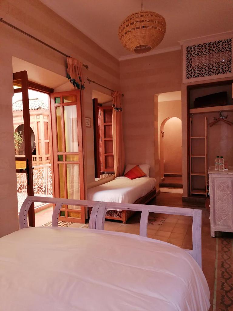 une chambre avec deux lits et un balcon dans l'établissement DAR MAR'OUKA , Maison d'hôtes, à Marrakech