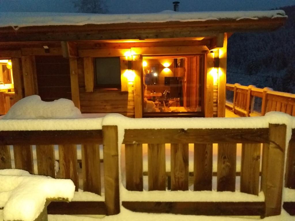 une cabine avec une terrasse couverte de neige la nuit dans l'établissement L'instant chalet Lodge 17, à Gérardmer