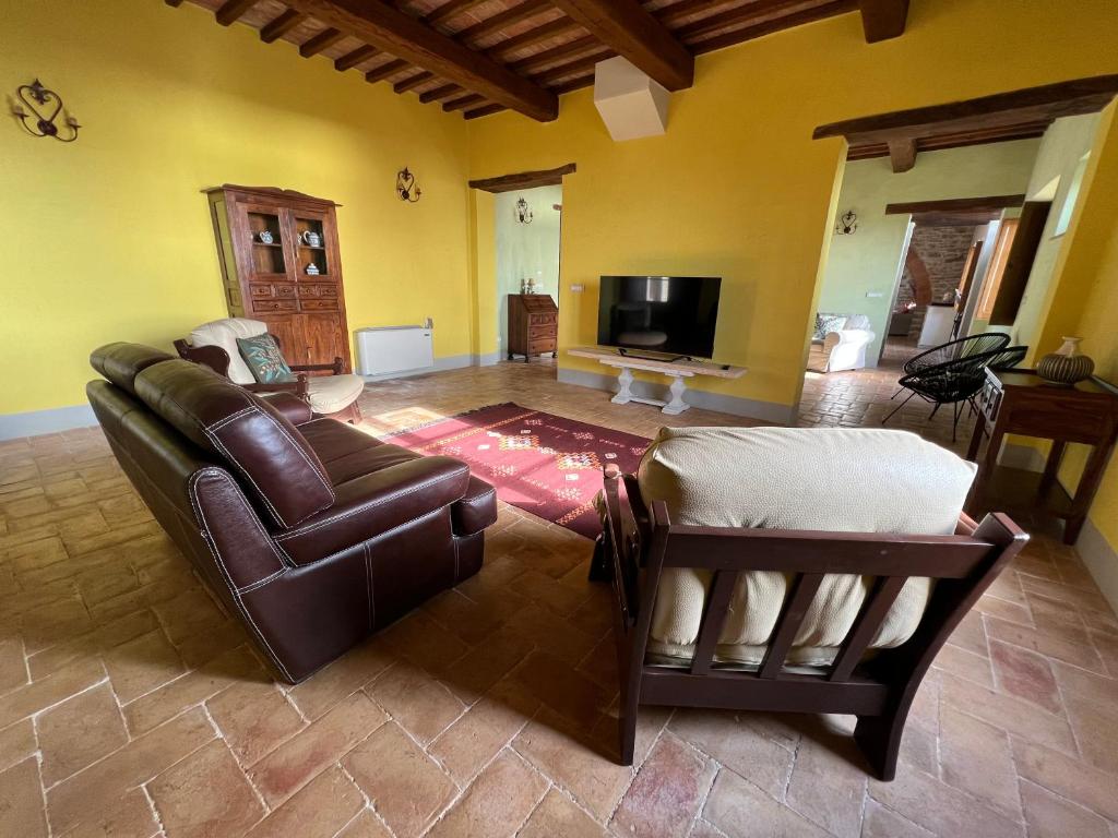 un salon avec un canapé et une télévision dans l'établissement Villa Gosparini, à Lisciano Niccone