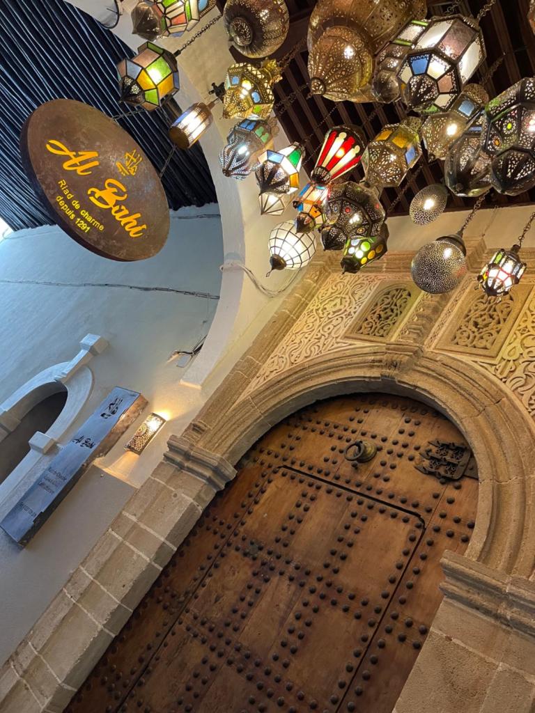 - un bâtiment avec une grande porte en bois et des lustres dans l'établissement Riad AL Bahi, à Rabat