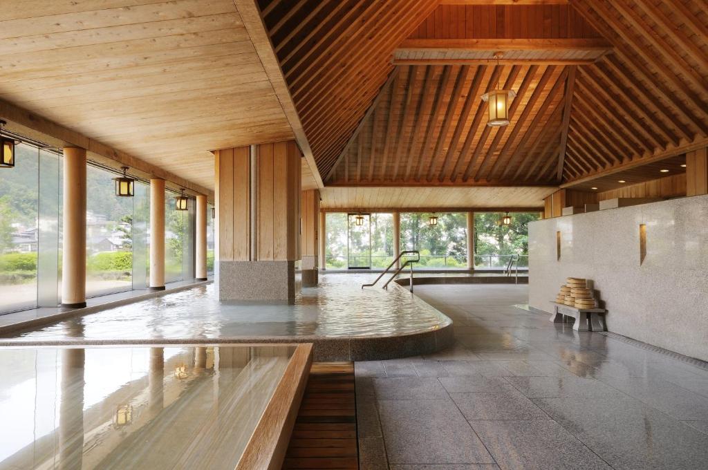 une grande chambre avec une table au centre d'un bâtiment dans l'établissement Suimeikan, à Gero