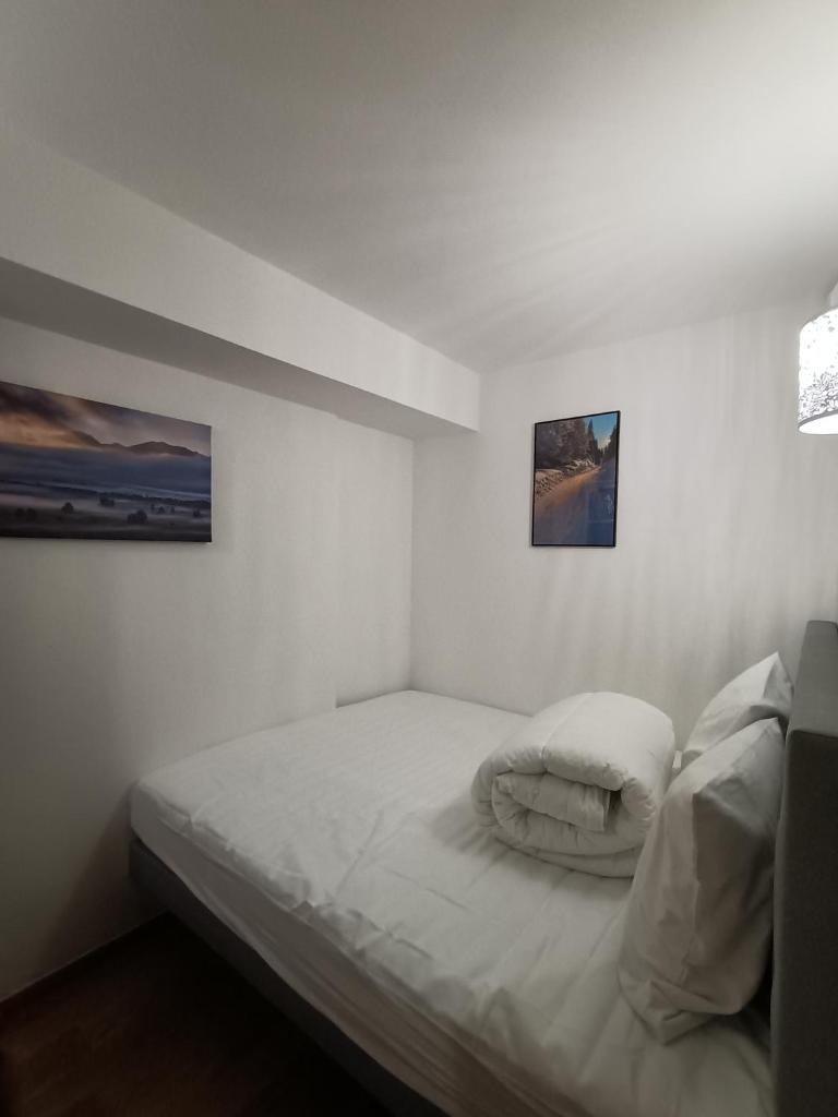 - une petite chambre avec un lit et deux photos sur le mur dans l'établissement Appartement la Plagne,7 pers rénové, à Aime La Plagne 2 autres photos