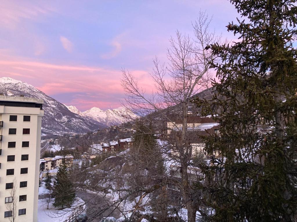 - un bâtiment avec vue sur une montagne enneigée dans l'établissement Le Flocon - 6 personnes, à Saint-Chaffrey