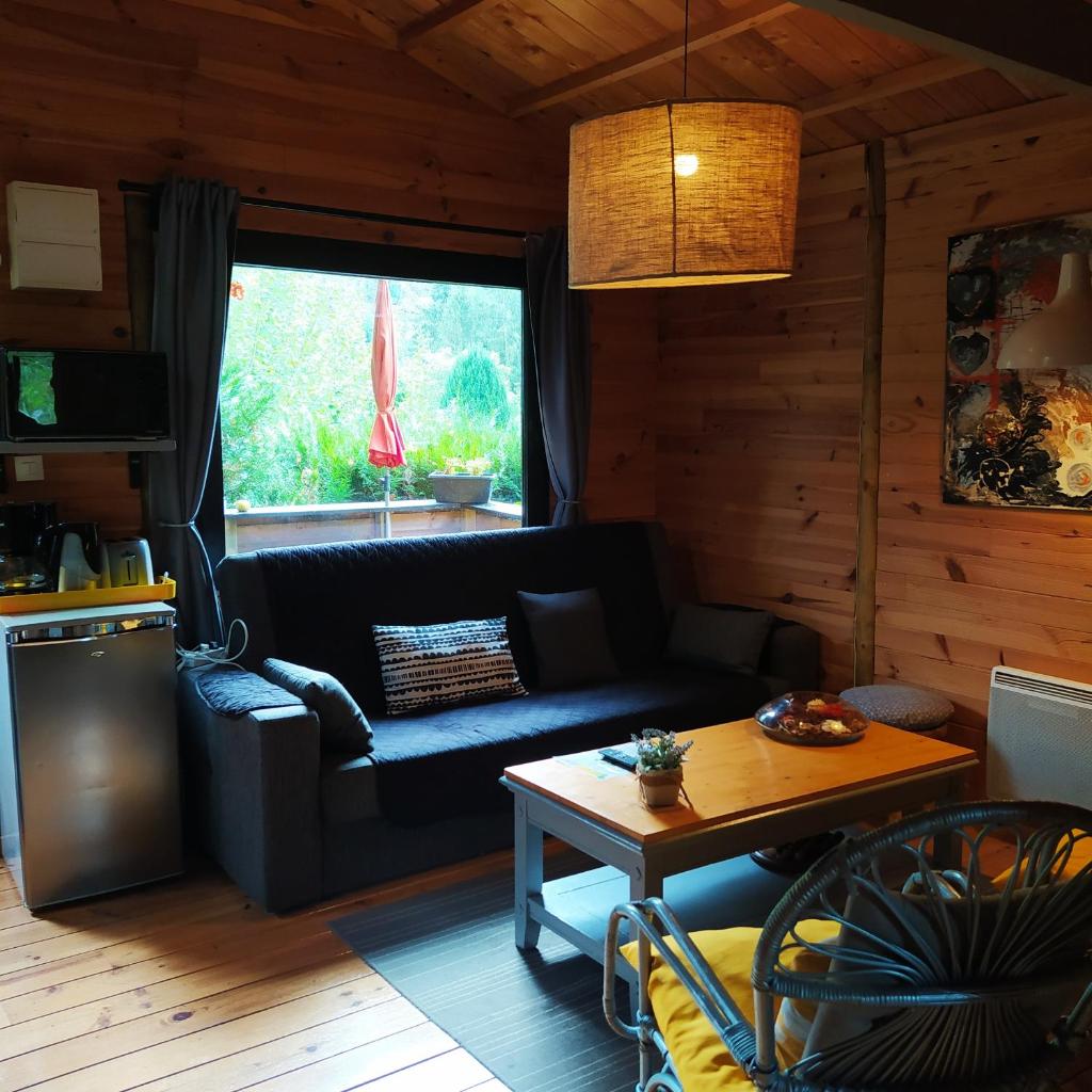 un salon avec un canapé et une table dans l'établissement CHALET Chataigne ETAPEBOISEE, à Fumay