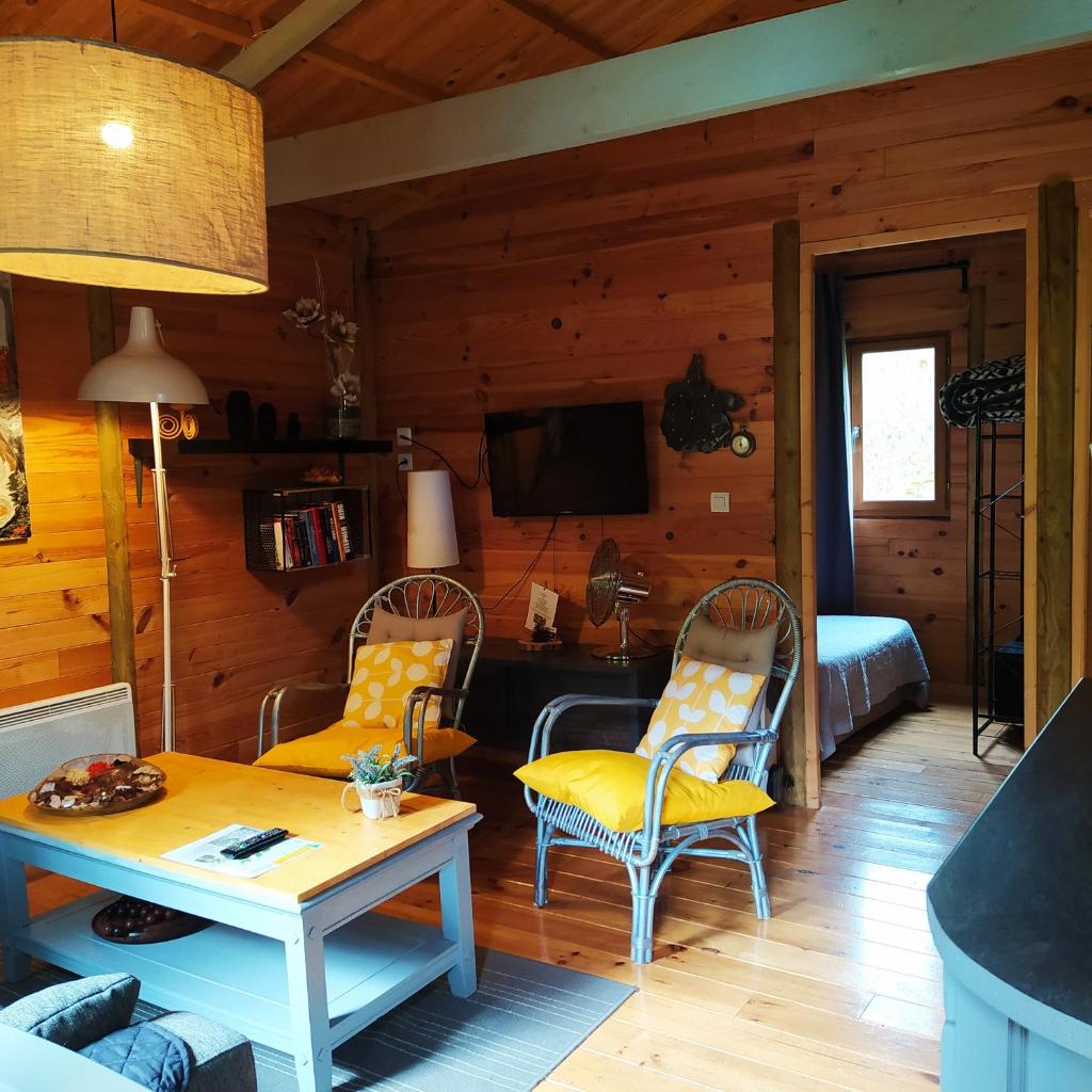 - un salon avec une table et des chaises dans une cabine dans l'établissement CHALET Chataigne ETAPEBOISEE, à Fumay