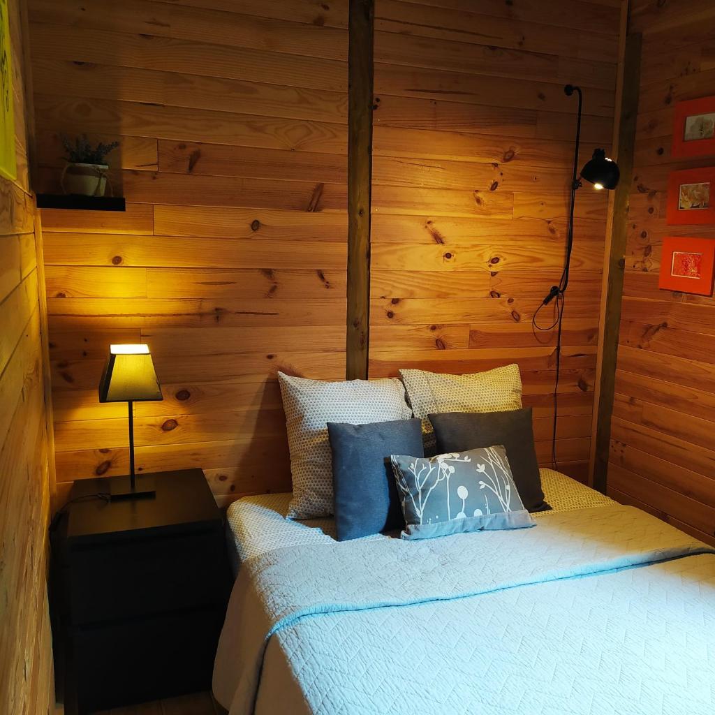 - une chambre avec un lit et un mur en bois dans l'établissement CHALET Chataigne ETAPEBOISEE, à Fumay