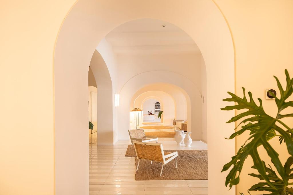 une arche mène à un salon avec une table et des chaises dans l'établissement Miramare Sea Resort & Spa, à Ischia