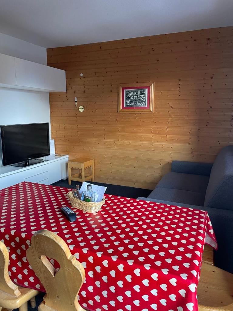 Cette chambre comprend une table avec un tissu de table rouge et blanc. dans l'établissement Studio 4 à 5 personnes - Les balcons de Sirius RISOUL, à Risoul