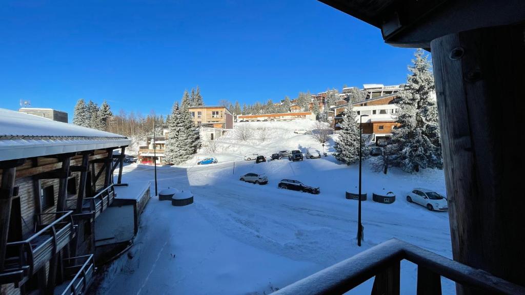 Elle offre une vue sur une rue enneigée depuis son balcon. dans l'établissement Balcon de Recoin 2 Personnes, à Chamrousse