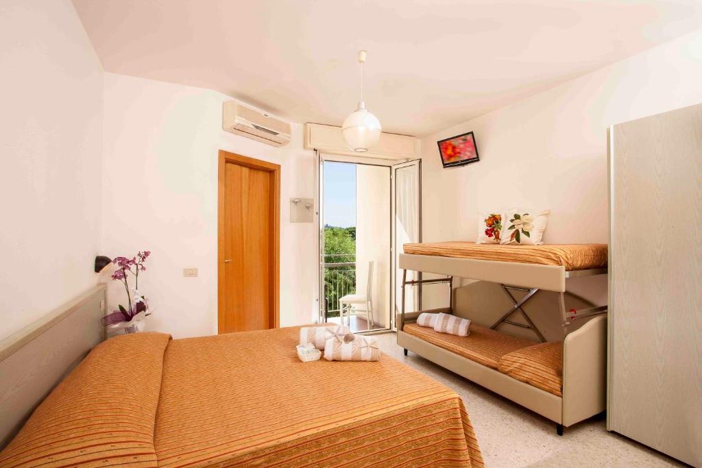 une chambre avec deux lits superposés et une fenêtre dans l'établissement Hotel leonardo, à Cattolica