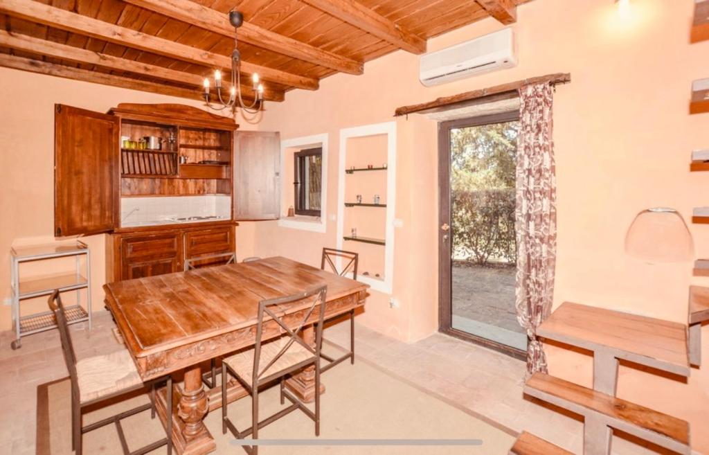 une salle à manger avec une table en bois et une fenêtre dans l'établissement Villa Ari, la tua villa in Toscana, à Reggello