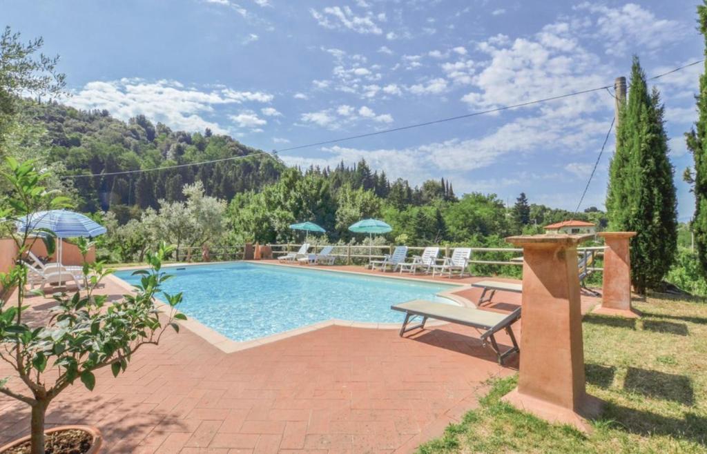 une piscine avec un banc à côté d'une maison dans l'établissement Villa Ari, la tua villa in Toscana, à Reggello