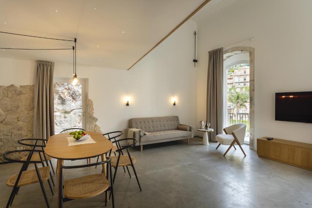 un salon avec une table, des chaises et un canapé dans l'établissement Villa Petra - IsulaTravel, à Modica