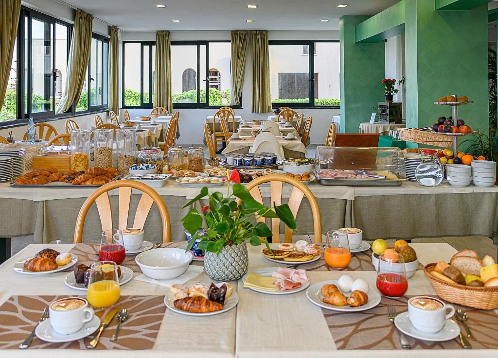 une longue table avec des assiettes de nourriture dessus dans l'établissement Hotel Paris, à Lido di Camaiore