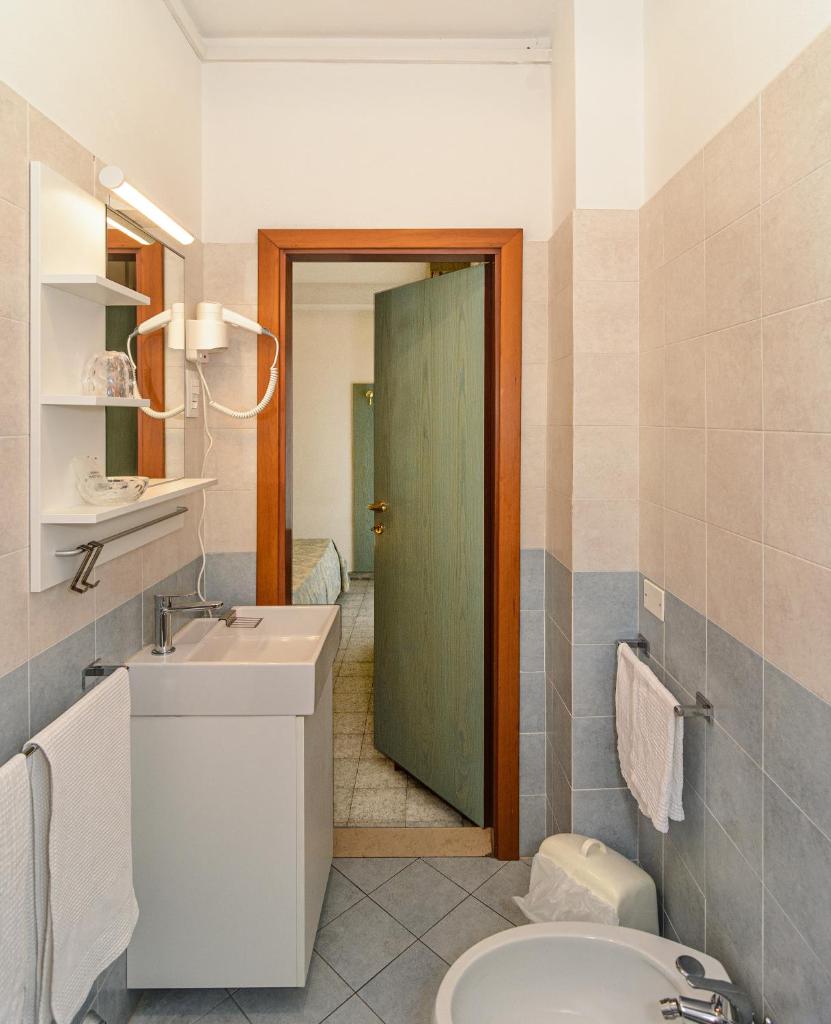 La salle de bains est pourvue d'un lavabo et d'une porte verte. dans l'établissement Hotel Paris, à Lido di Camaiore