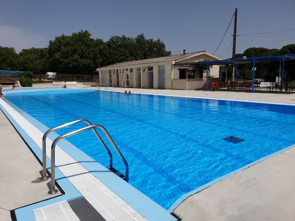 une grande piscine avec de l'eau bleue dans l'établissement CAMPING LE BEL AIR mobil home LE CORNOUILLER 4 personnes, à Limogne-en-Quercy