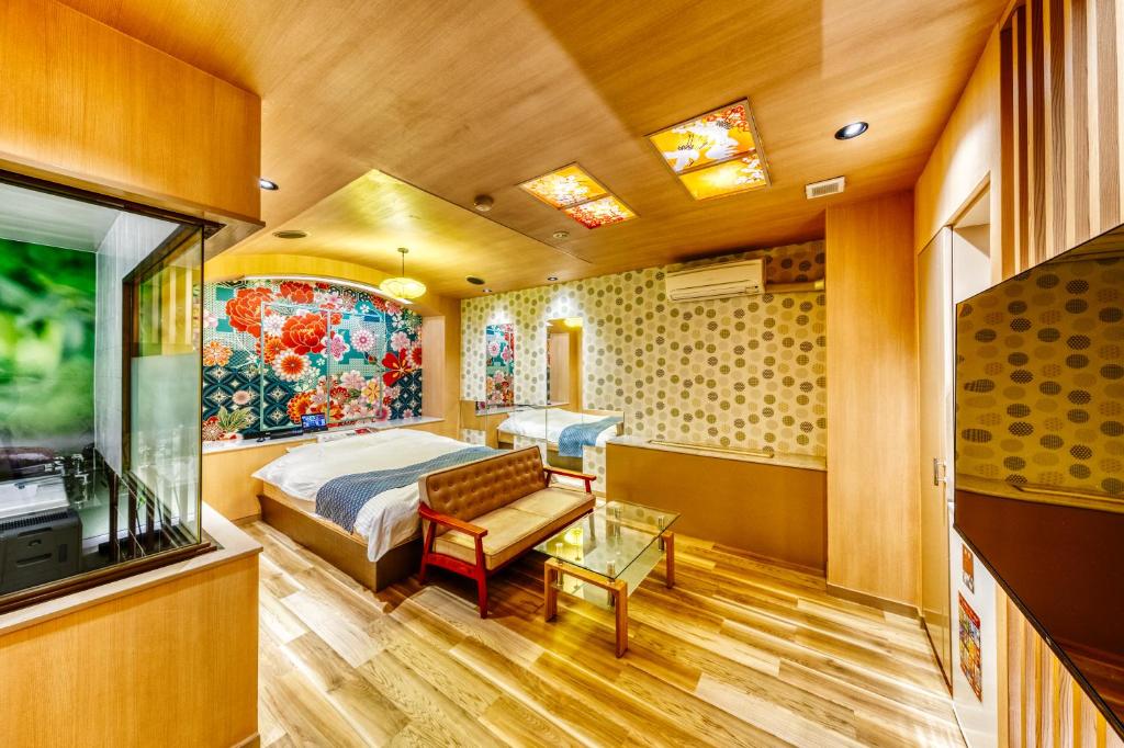 une chambre avec un lit et une télévision dans une pièce dans l'établissement Hotel Lotus Higashiosaka -Adult Only, à Osaka