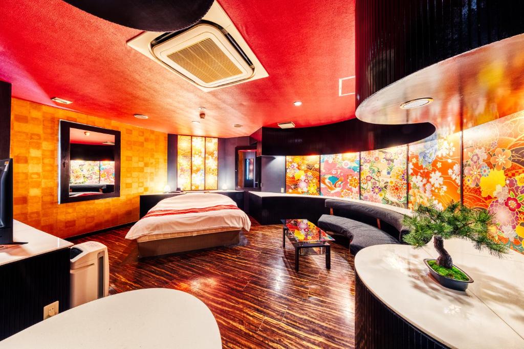 un salon avec un lit et un canapé dans l'établissement Hotel Lotus Higashiosaka -Adult Only, à Osaka 5 autres photos