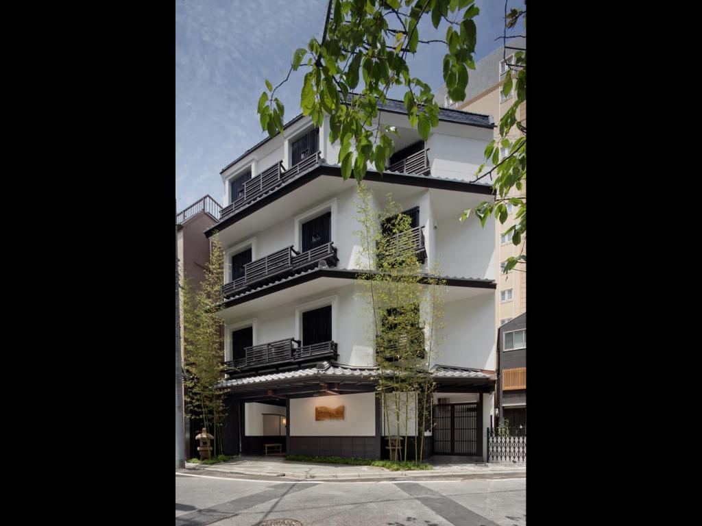- un bâtiment blanc avec des balcons noirs et un arbre dans l'établissement The Edo Sakura, à Tokyo