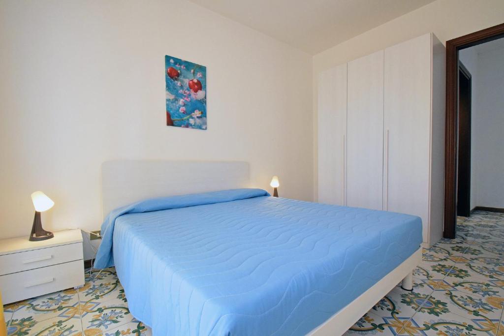 une chambre avec un lit avec un couvre-lit bleu dans l'établissement Residence Le Magnolie, à Martinsicuro