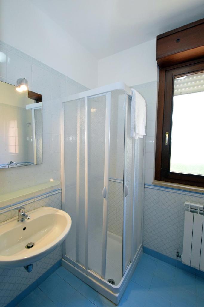une salle de bain avec douche et lavabo dans l'établissement Residence Le Magnolie, à Martinsicuro