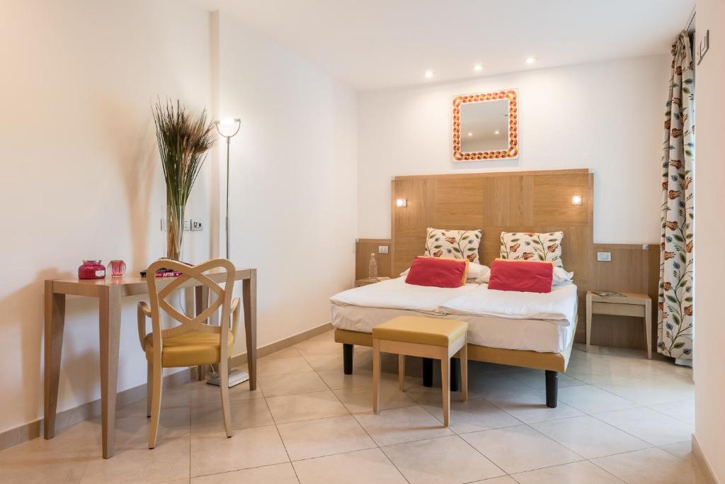 une chambre avec un lit, une table et une chaise dans l'établissement Hotel Katja, à Bibione