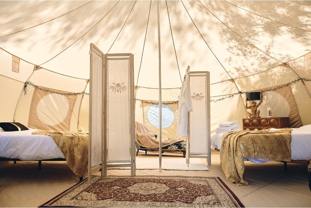 une chambre avec deux lits dans une tente dans l'établissement Camping d'artagnan, à Margouët-Meymès
