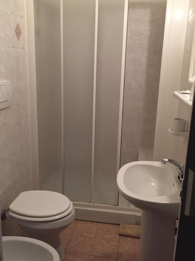 une salle de bain avec une douche, des toilettes et un lavabo dans l'établissement Hotel Nuova Doel, à Sottomarina 22 autres photos