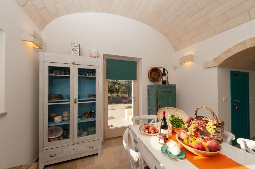 une cuisine avec une table avec un bol de fruits dessus dans l'établissement TRULLI ACQUASALA - Apulian Country Experience, à Ostuni