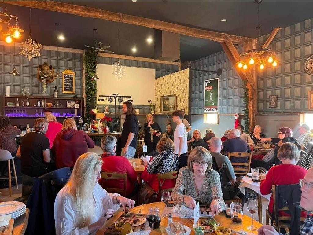 un groupe de personnes assises à des tables dans un restaurant dans l'établissement Camping d'artagnan, à Margouët-Meymès