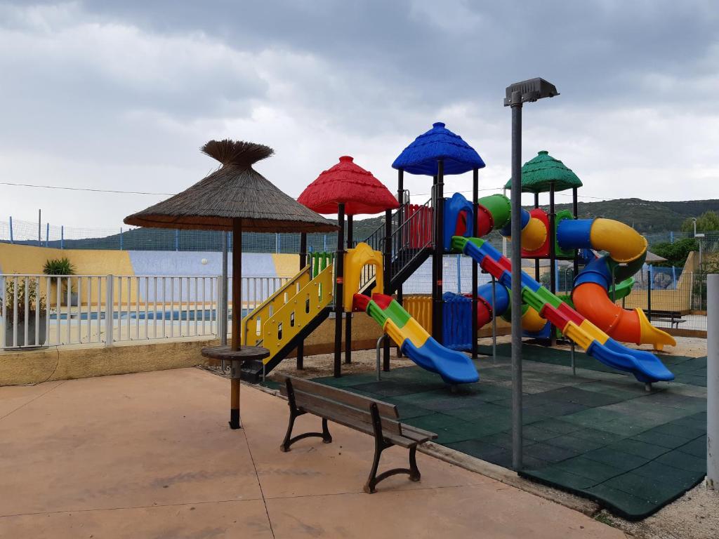 - une aire de jeux avec toboggan et banc dans l'établissement Mobil Home Camping New Day, à Vic-la-Gardiole