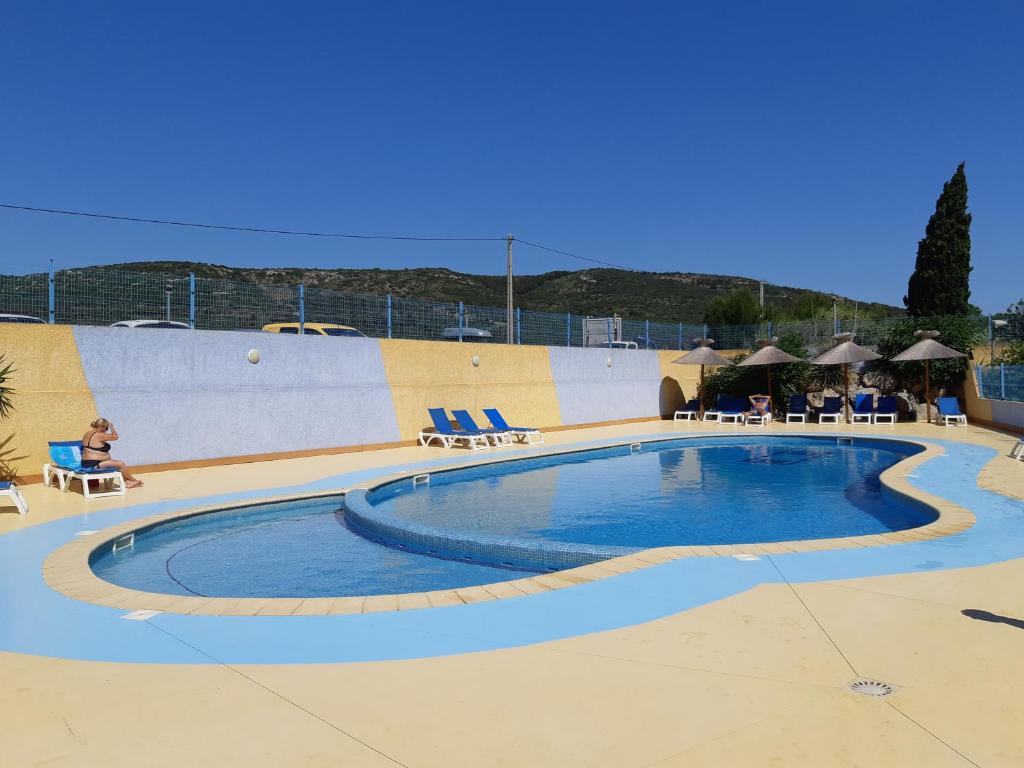 - une grande piscine avec une personne assise dans une chaise à côté dans l'établissement Mobil Home Camping New Day, à Vic-la-Gardiole