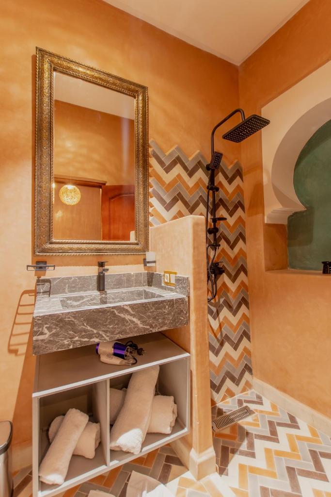 une salle de bain avec un lavabo et un miroir dans l'établissement RIAD MARRAKECH DOORS, à Marrakech