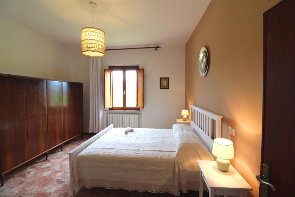 une chambre avec un grand lit blanc et une fenêtre dans l'établissement CASA ANGELA, à Castiglion Fiorentino 24 autres photos