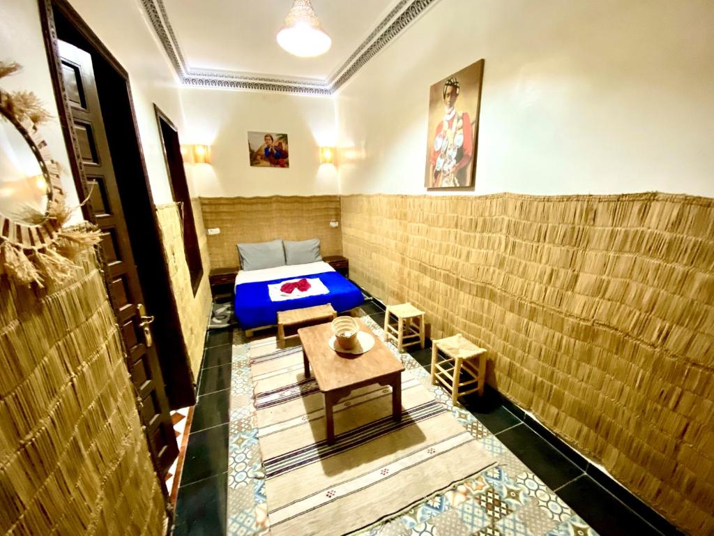 une pièce avec un lit et une table dedans dans l'établissement Riad Jibraile, à Marrakech