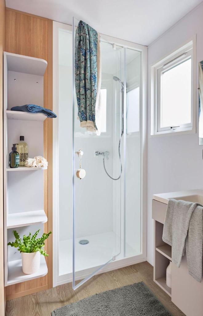 une salle de bain avec une douche avec une porte vitrée dans l'établissement Camping LES PEUPLIERS, à Hyères 26 autres photos