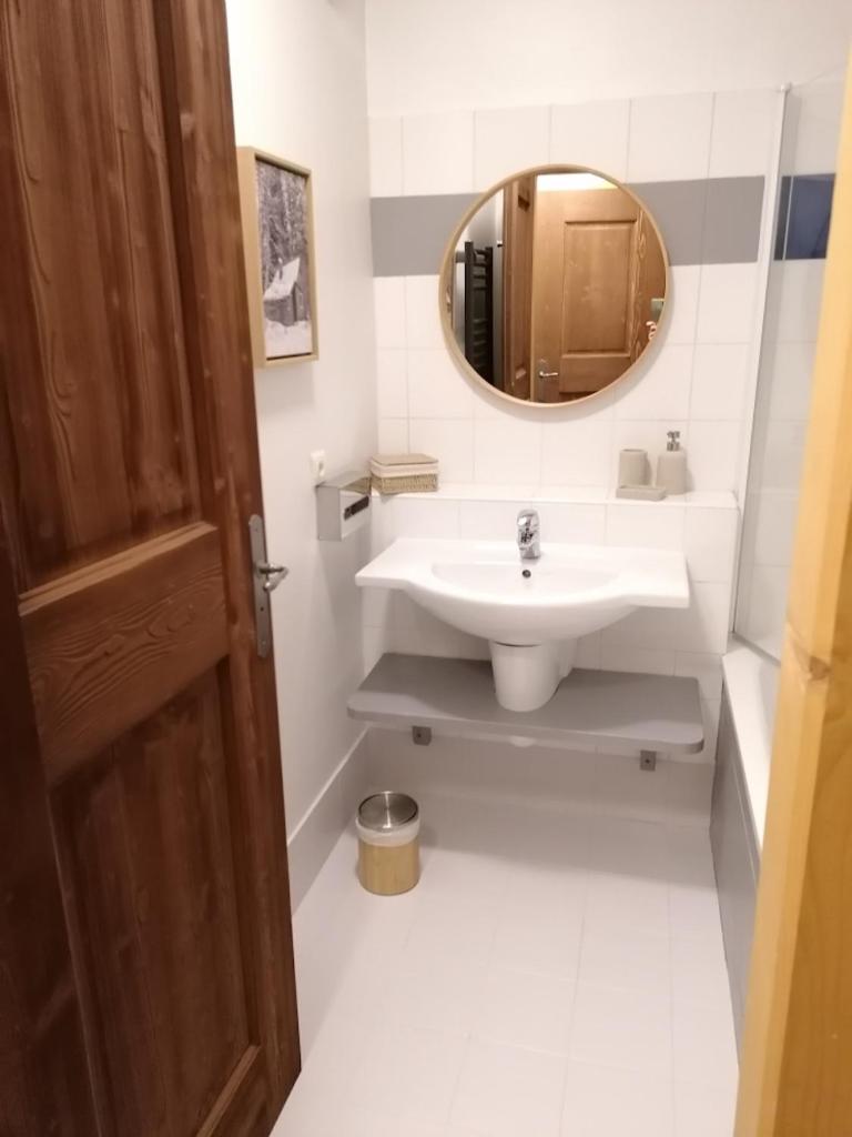 une salle de bain avec un lavabo et un miroir dans l'établissement Arc 1950 Appartement 4 personnes Ski aux pieds, à Arc 1950 13 autres photos
