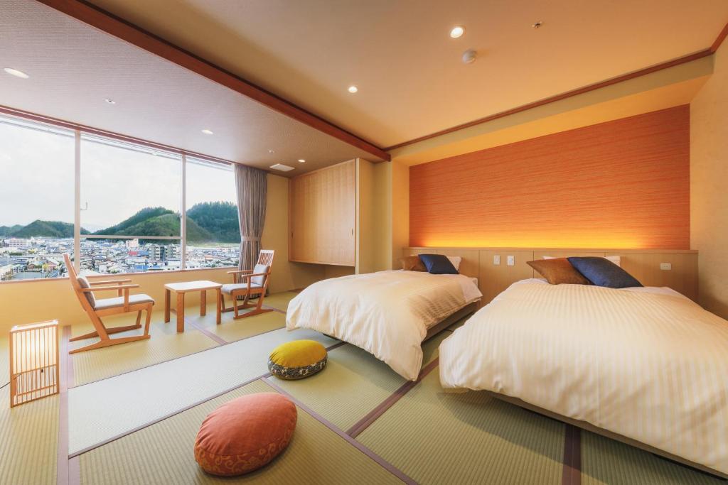 une chambre avec deux lits et une table et des chaises dans l'établissement Tendo Hotel, à Tendō