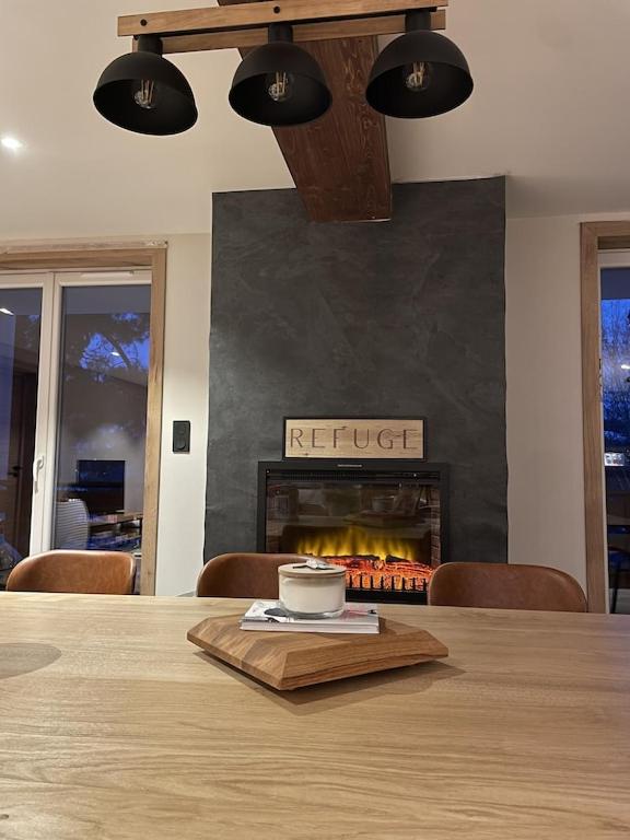- une table à manger avec une cheminée et une tasse dans l'établissement LE REFUGE LES 2 ALPES 1800, à Les Deux Alpes