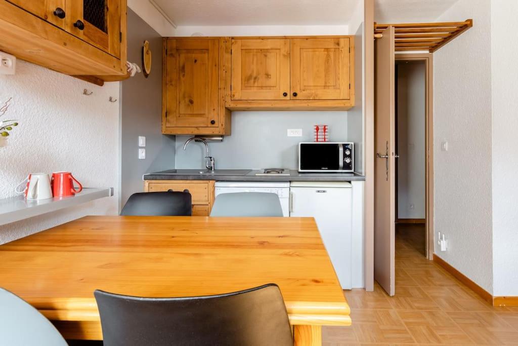 une cuisine avec une table en bois et un micro-ondes dans l'établissement Les gentianes 311, aux Menuires 23 autres photos