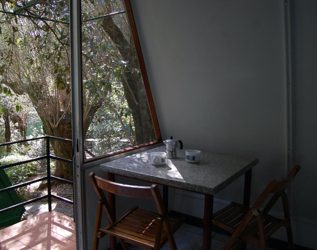 une table et deux chaises dans une pièce avec une fenêtre dans l'établissement La Francesca Sud un villaggio"glamping", à Scario